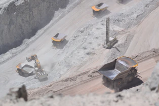A team coordinating logistics operations at a mining site with trucks and equipment.