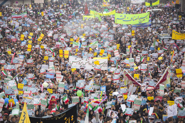 A vibrant street protest with colorful banners and engaged crowd.