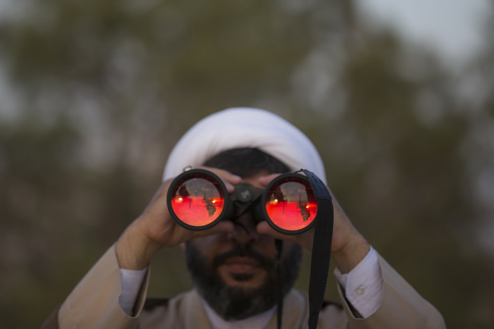 man holding black binoculars