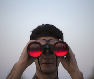 person holding black binoculars