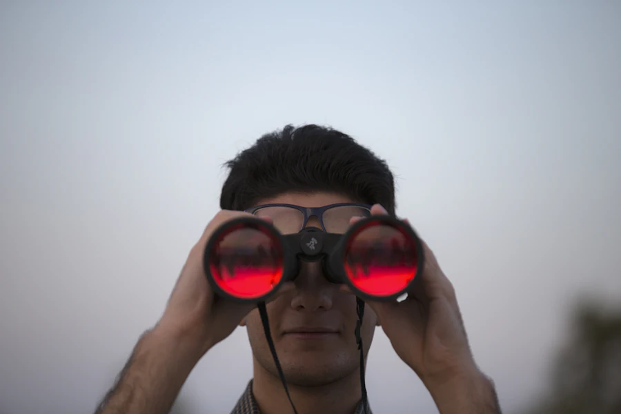 Private investigator watching through binoculars