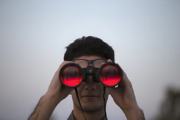 Person holding binoculars looking at stars