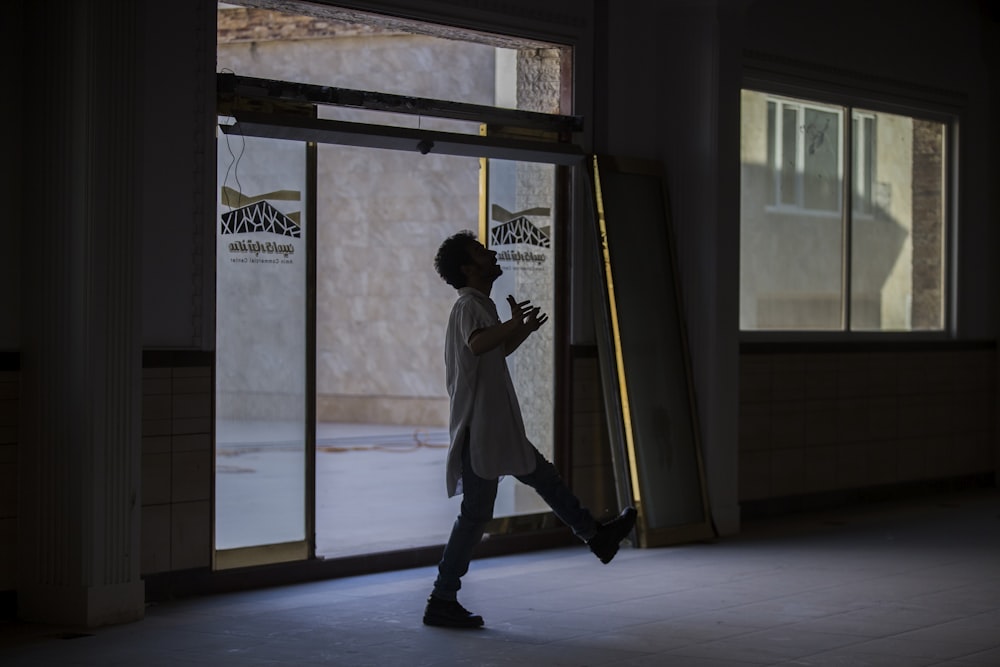 man standing beside open door inside building during daytime