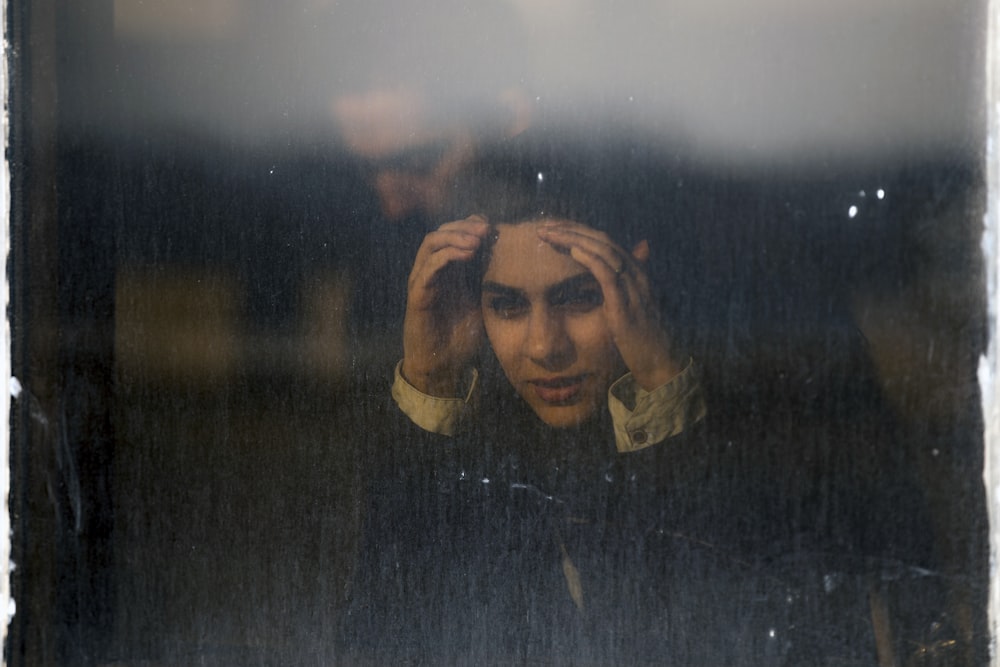 woman peaking on glass window panel