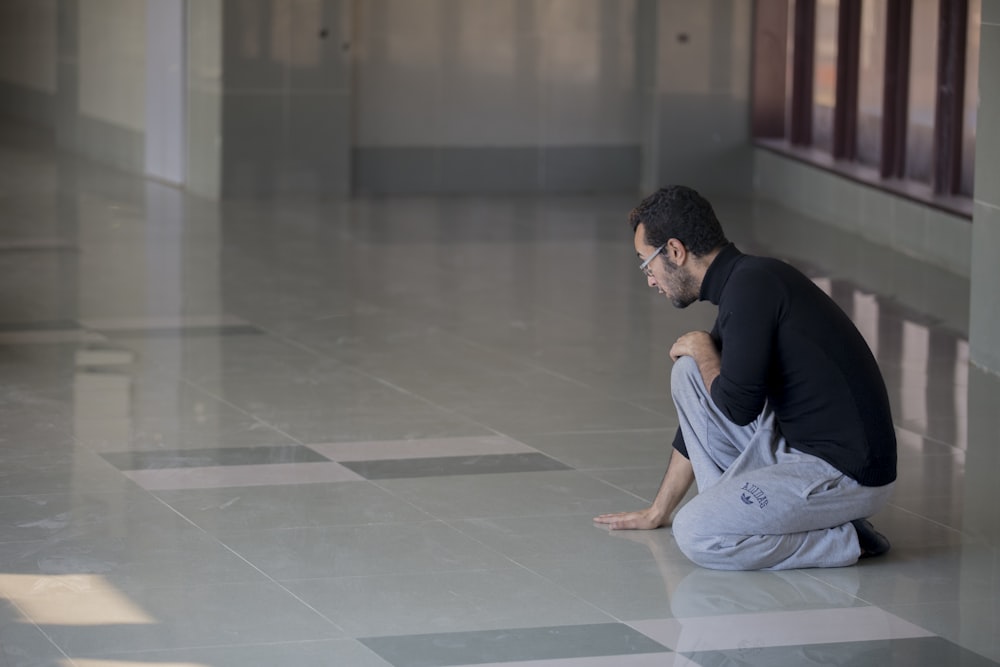 man squatting on floor