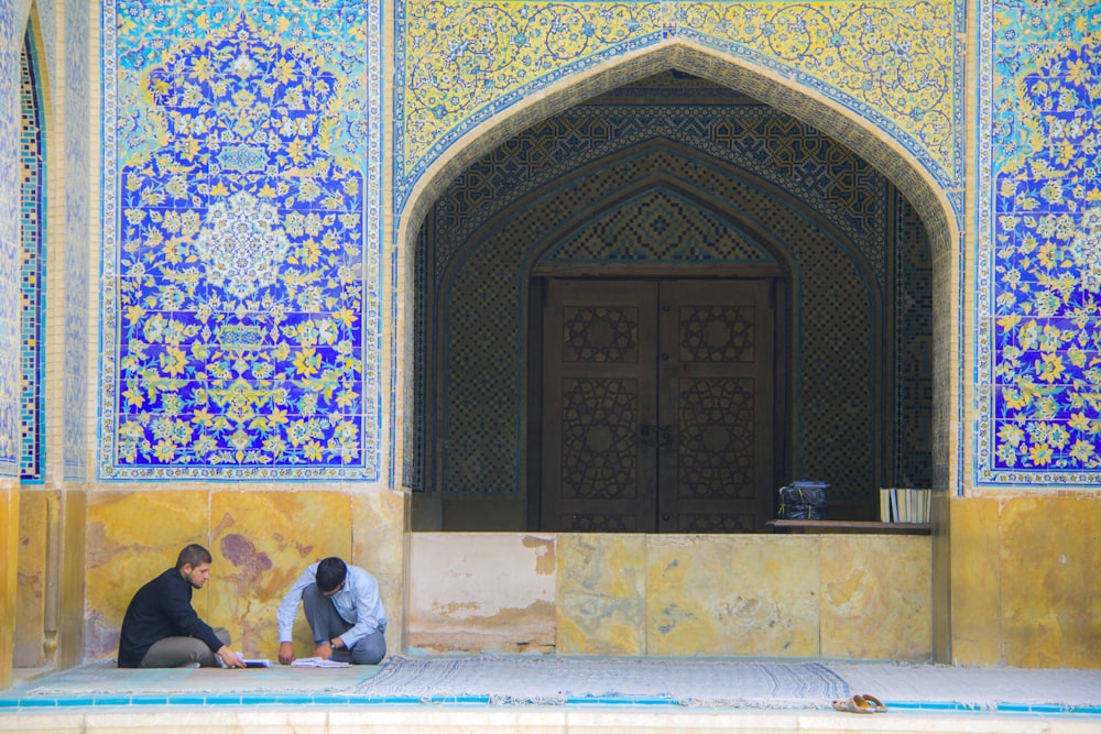 men sitting beside building