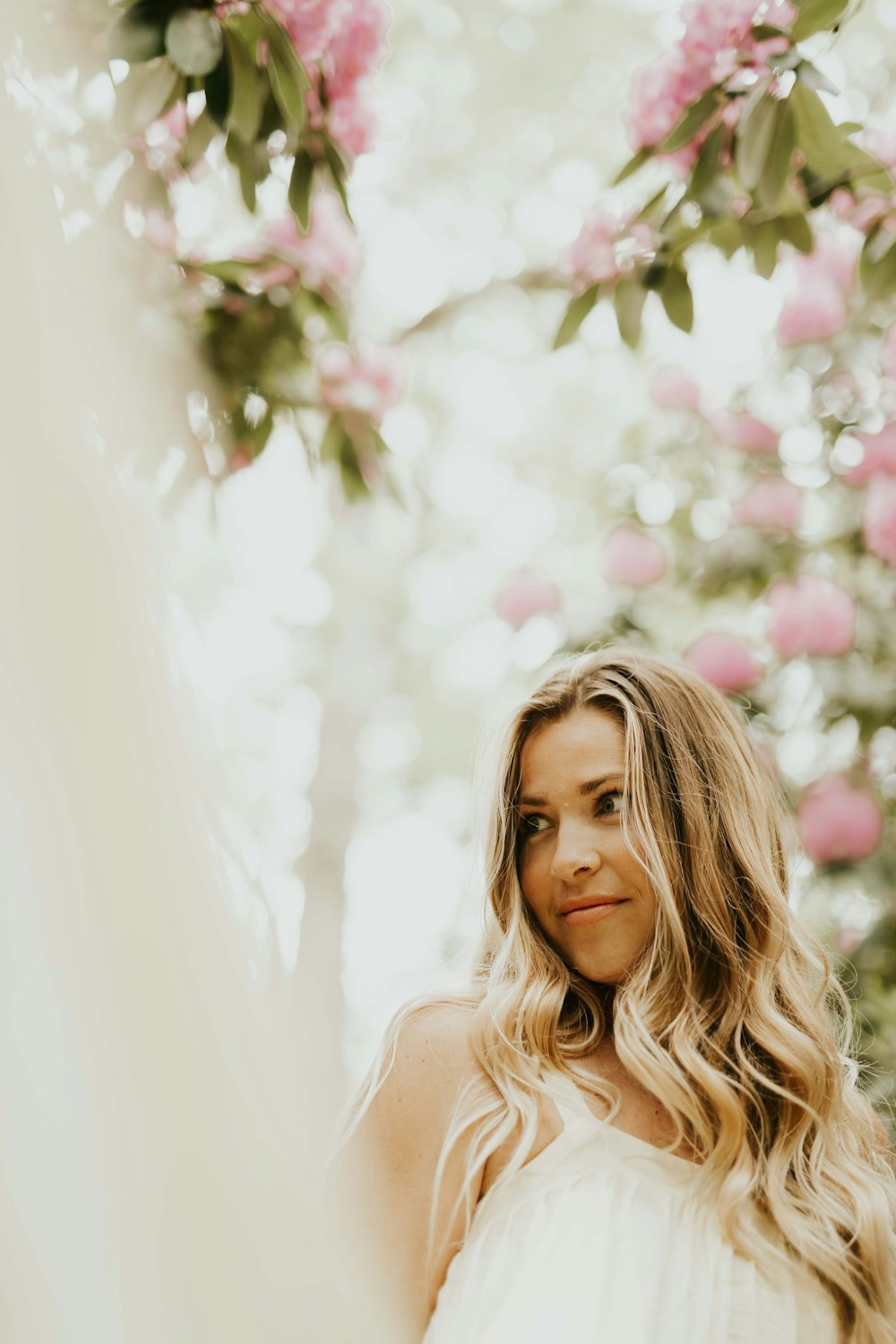 selective focus photography of woman surrounded with flowers