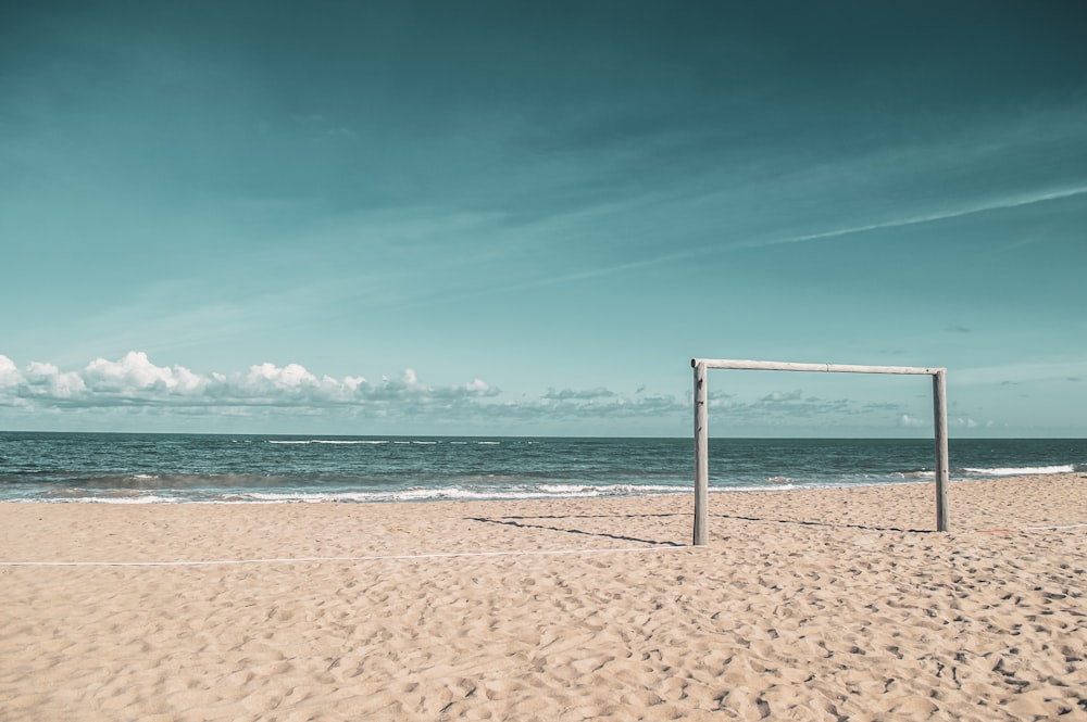 portiere in piedi alle dune di sabbia vicino alla riva del mare