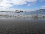 A jetski tour group cruising near the rocky coastline, waves gently splashing.