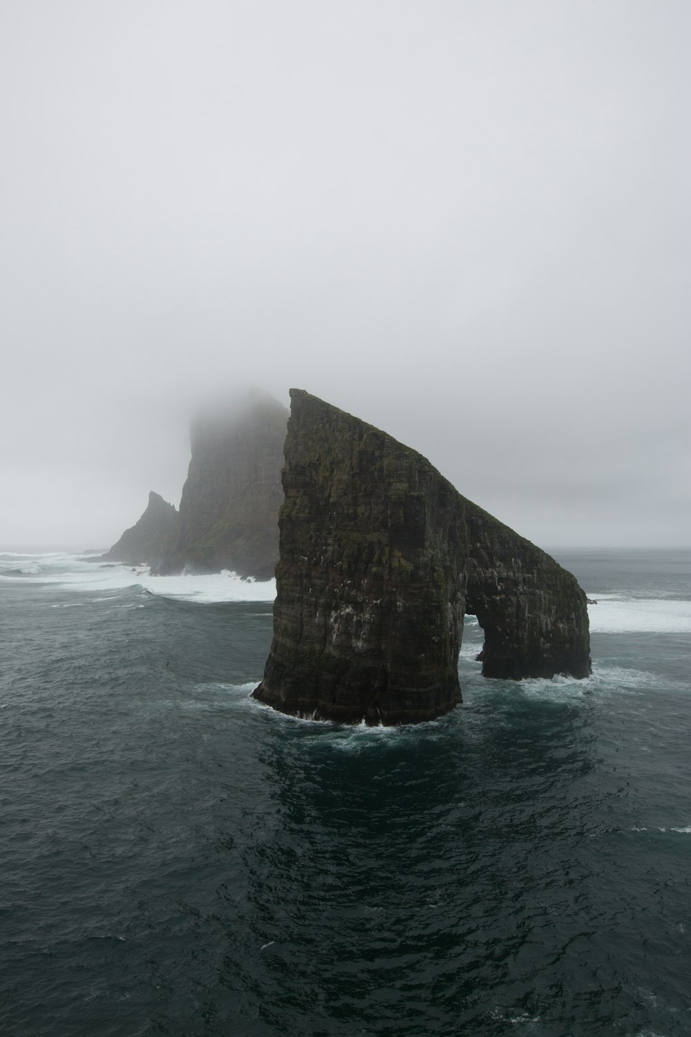 brown rock formation between body of water