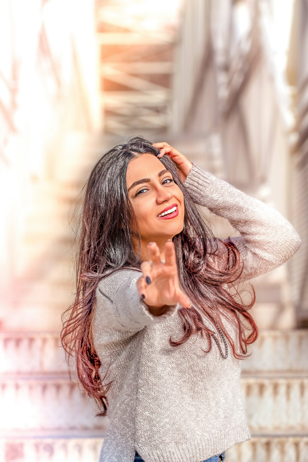 woman wearing gray long-sleeved shirt reaching hand