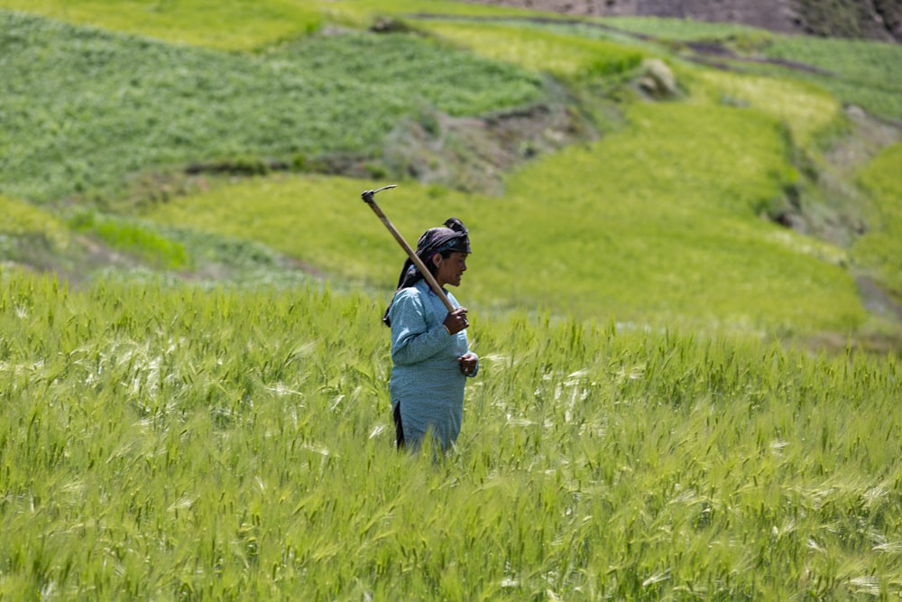 person holding hoe on grass land