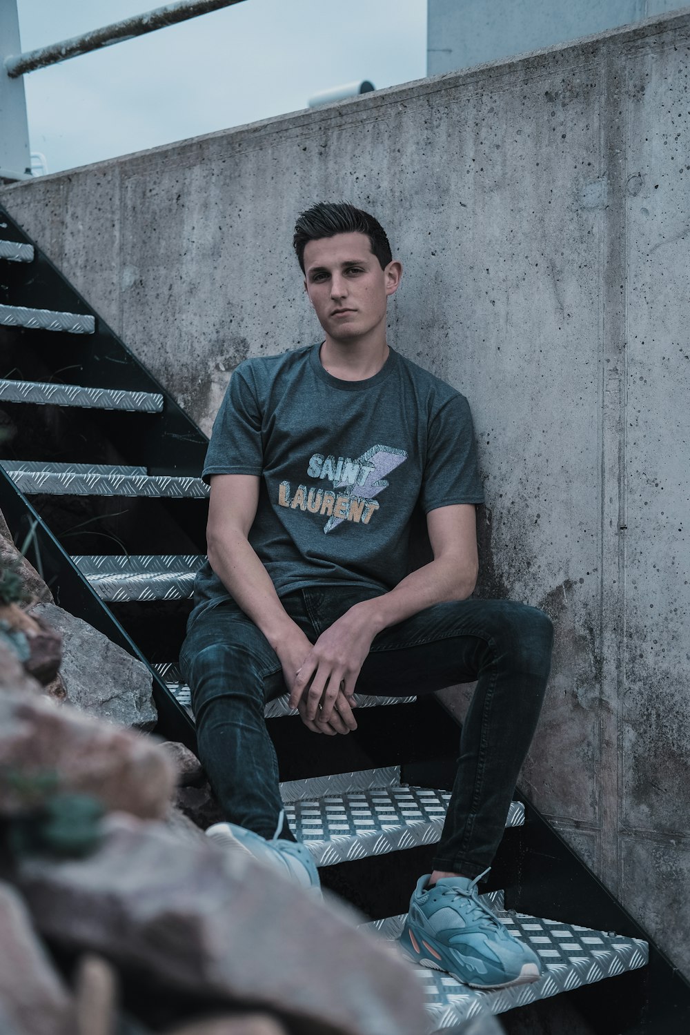 man sitting on metal stairs