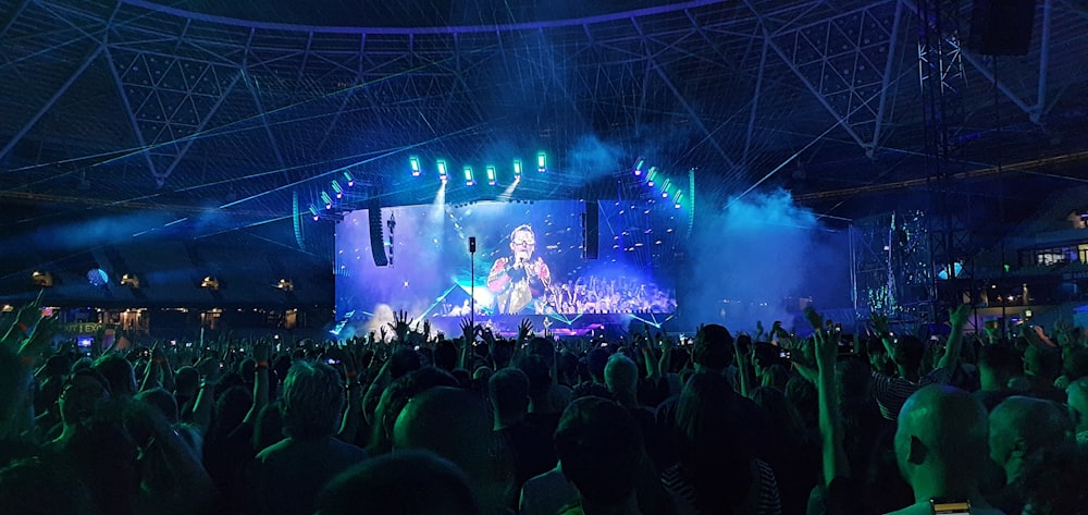 people gathering in event watching group of people performing on stage