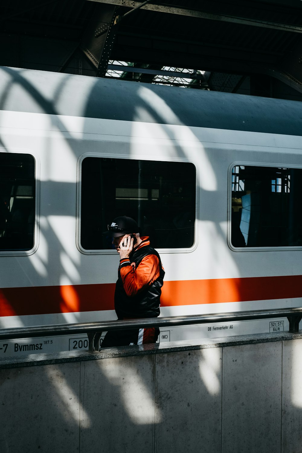 person walking near white and orange train