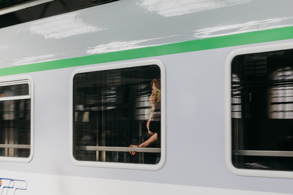a woman in a bathing suit is reflected in the windows of a train
