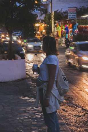 A delivery person holding a bottle of water in a modern urban setting.