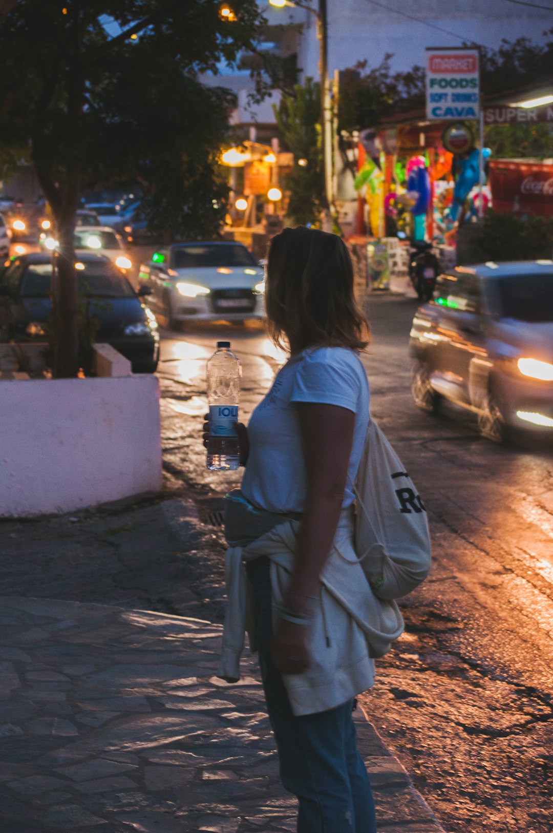 woman holding plastic water bottle outdoor during daytime