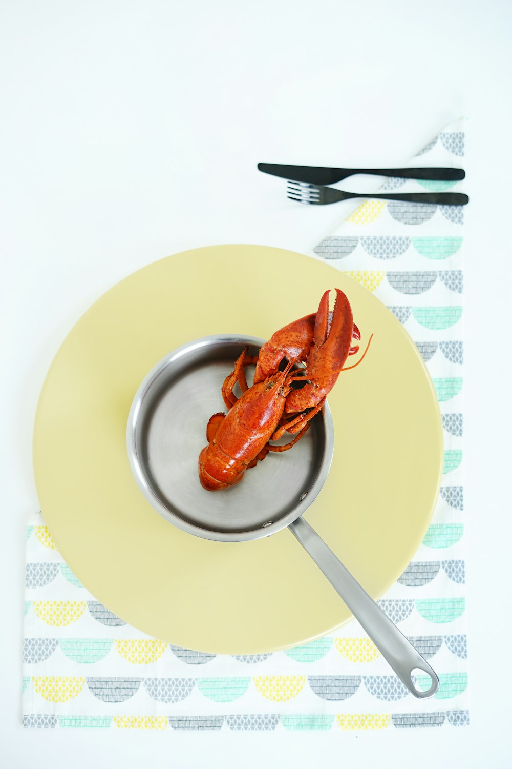lobster in pot on yellow surface