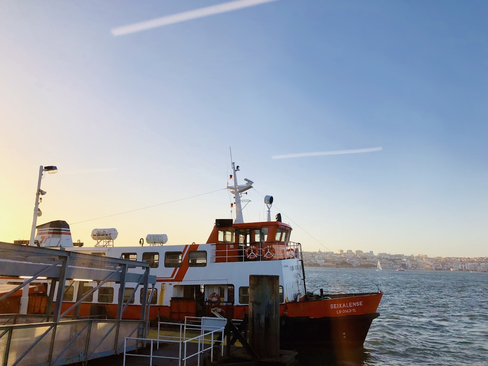 red and white fishing boat on pier