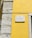A street sign is mounted on a vibrant yellow wall next to a section of exposed stonework on a building. The sign reads 'Rua da Conceição da Glória' and is attached to the wall with visible screws.