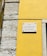 A street sign is mounted on a vibrant yellow wall next to a section of exposed stonework on a building. The sign reads 'Rua da Conceição da Glória' and is attached to the wall with visible screws.