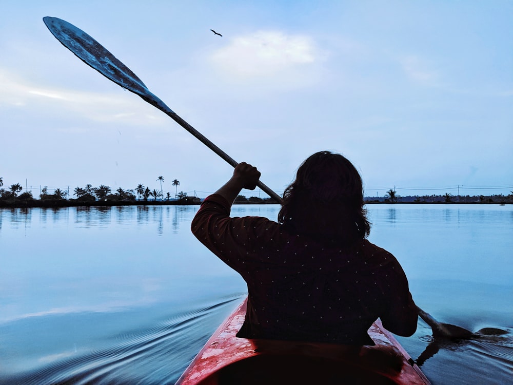 man riding kayak holding oar