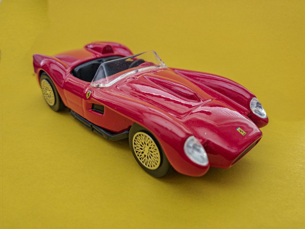 red sports coupe toy on yellow surface