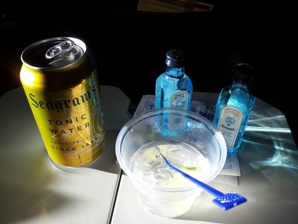 tonic water can beside liquid filled disposable cup