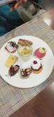 A variety of plated desserts arranged neatly on a white ceramic surface.