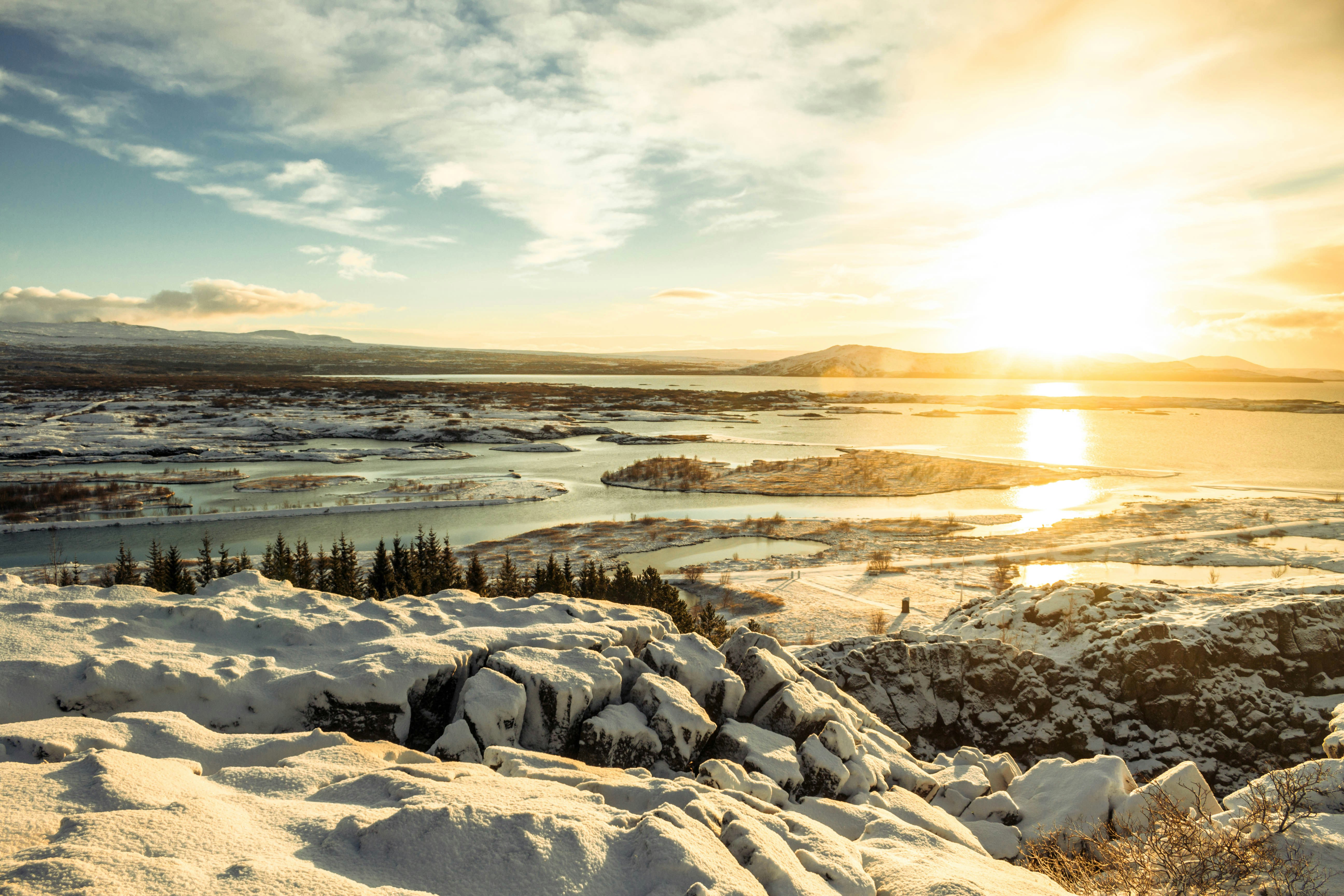 snow and tree covered islands during golden hour
