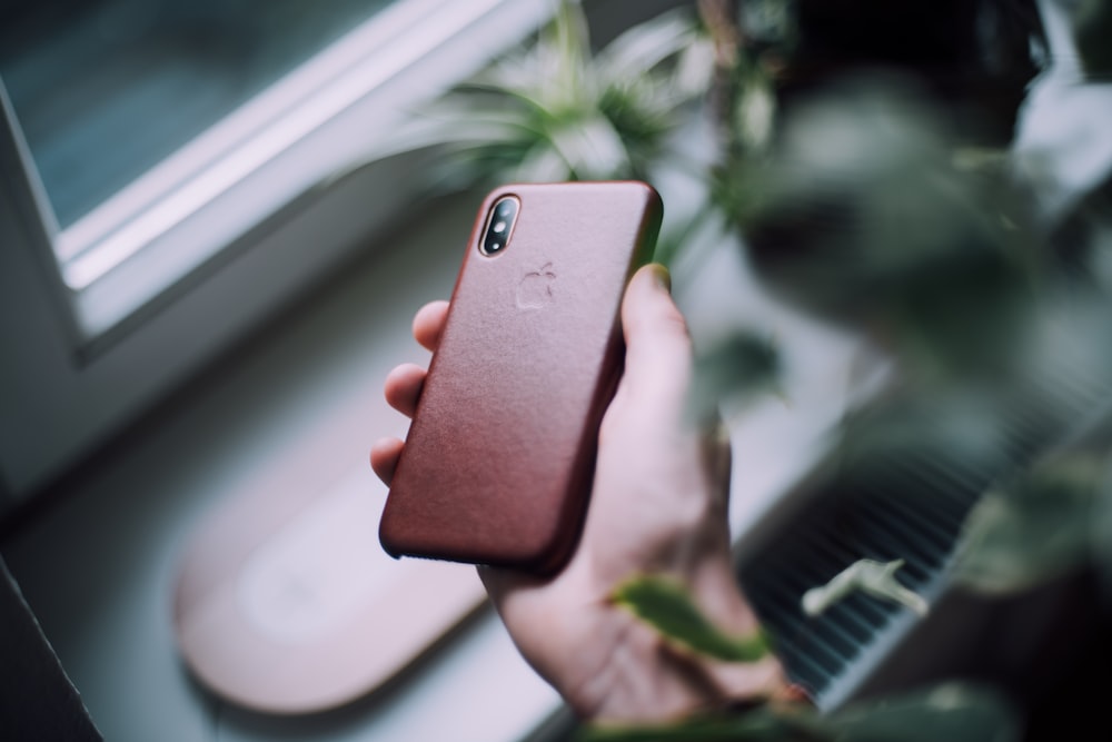 iPhone X prateado com capa vermelha