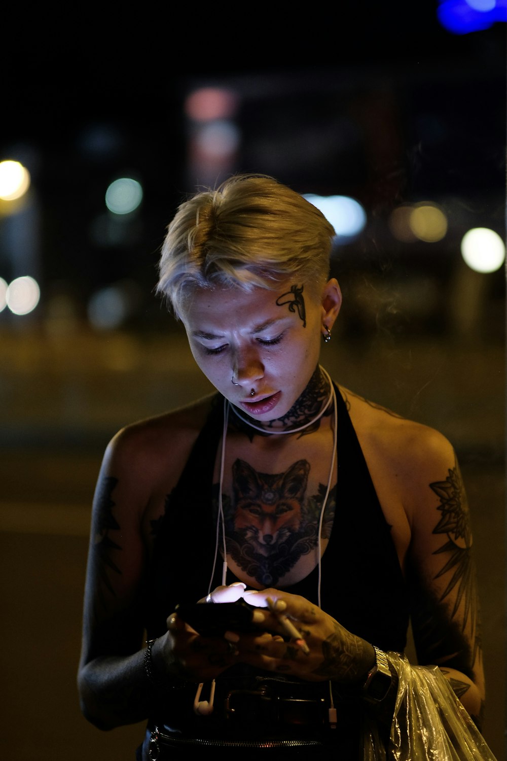 woman in black halter top using smartphone at the street