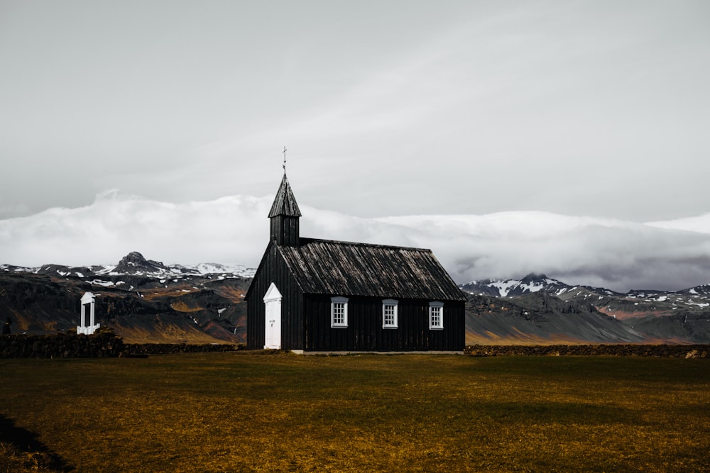 black and white wooden house in brown field