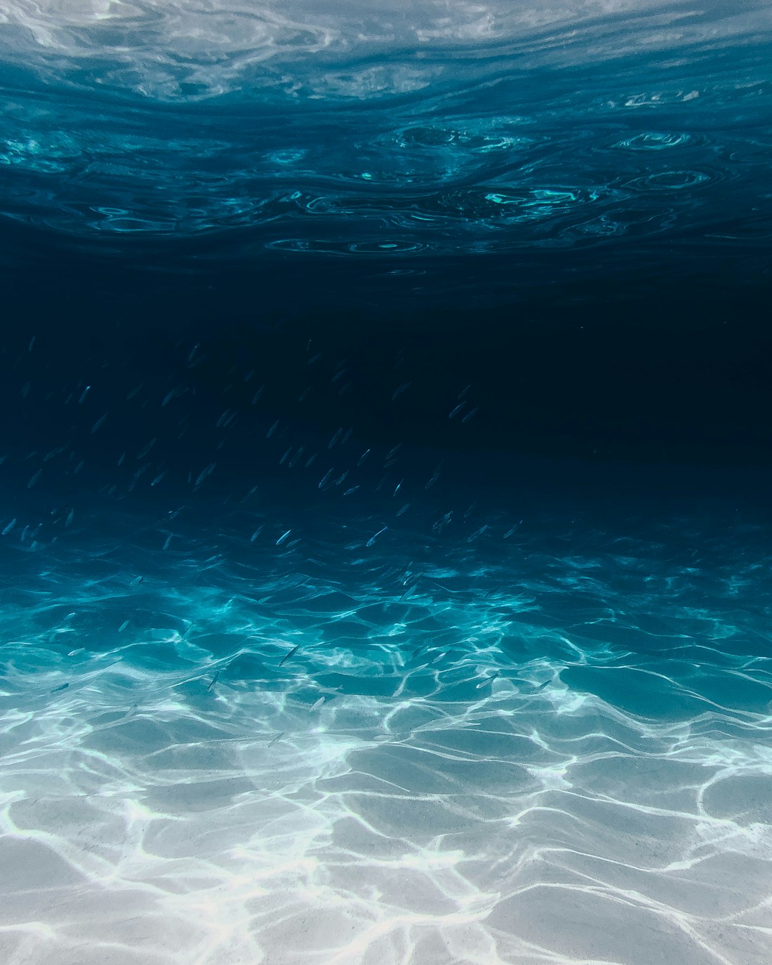 Deep blue water over rippled sand