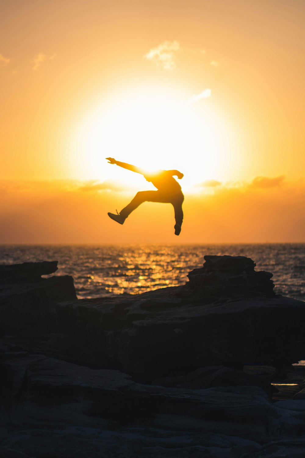 silhouette of man jumping mid air