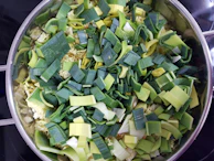 An extra-large pot filled with fresh vegetables ready to be cooked.