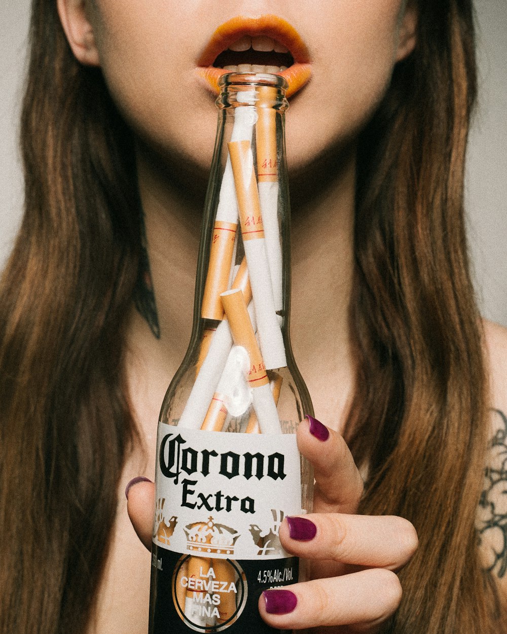 woman holding Corona Extra beer bottle