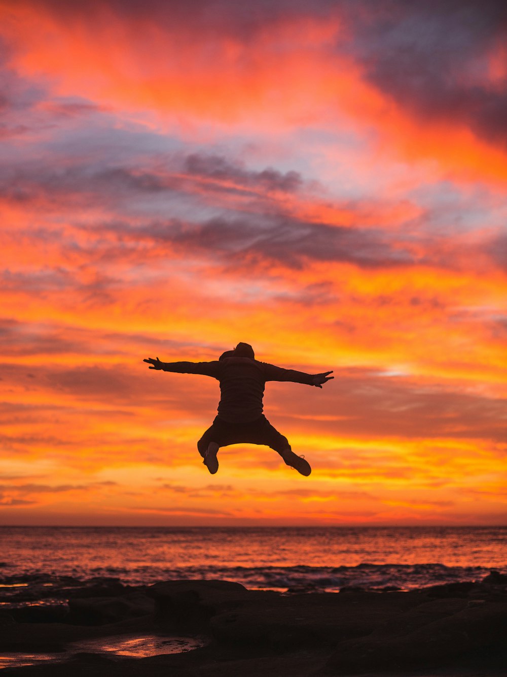 man jumping in seashore