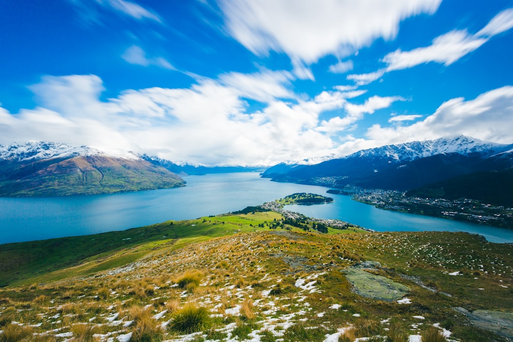 body of water beside mountain during daytime