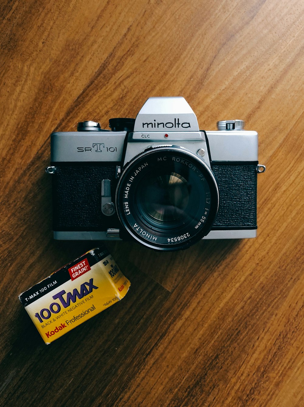 graue und schwarze Minolta-Kamera auf brauner Holzoberfläche