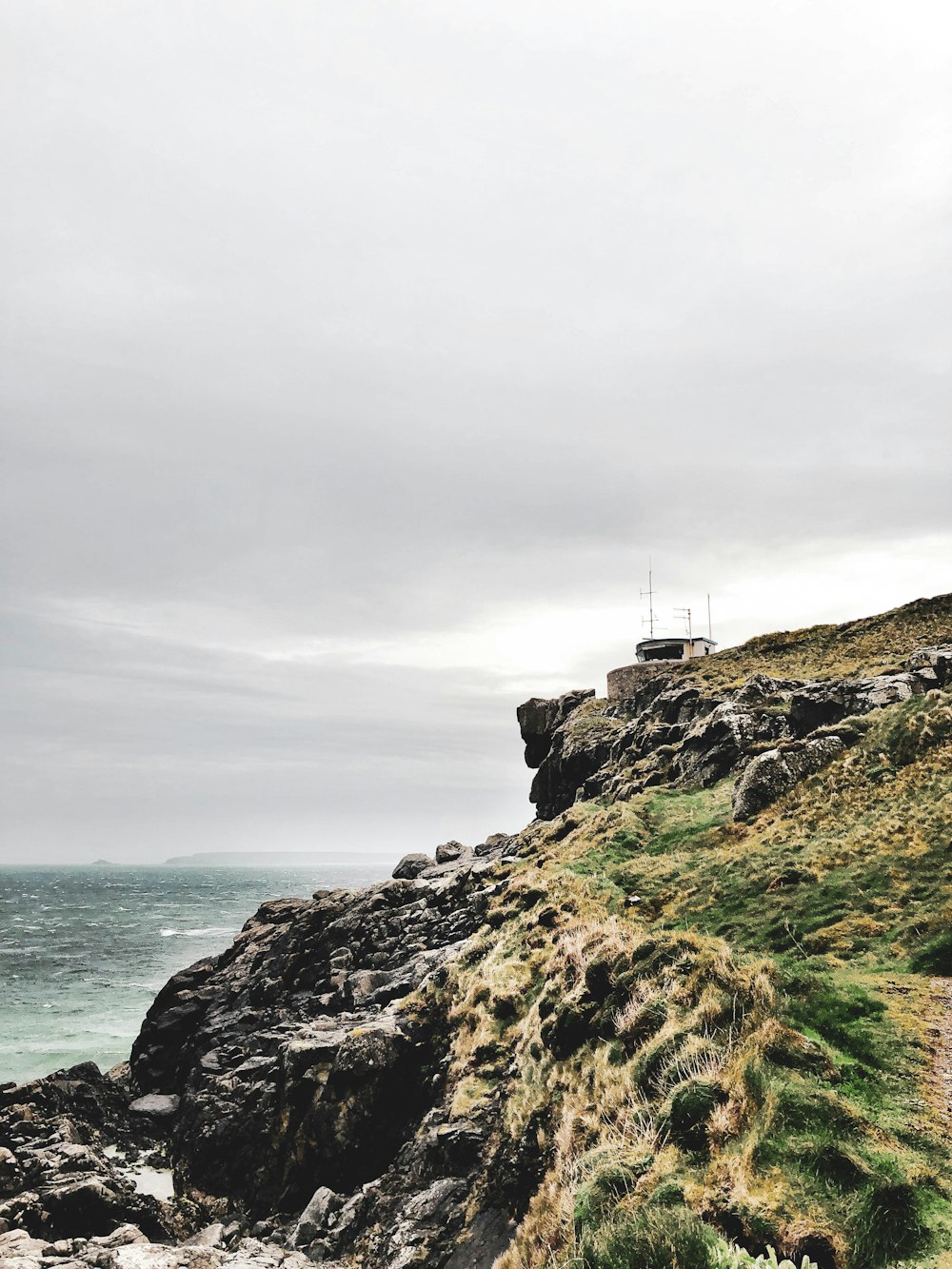 house near the edge of island's mountain during day