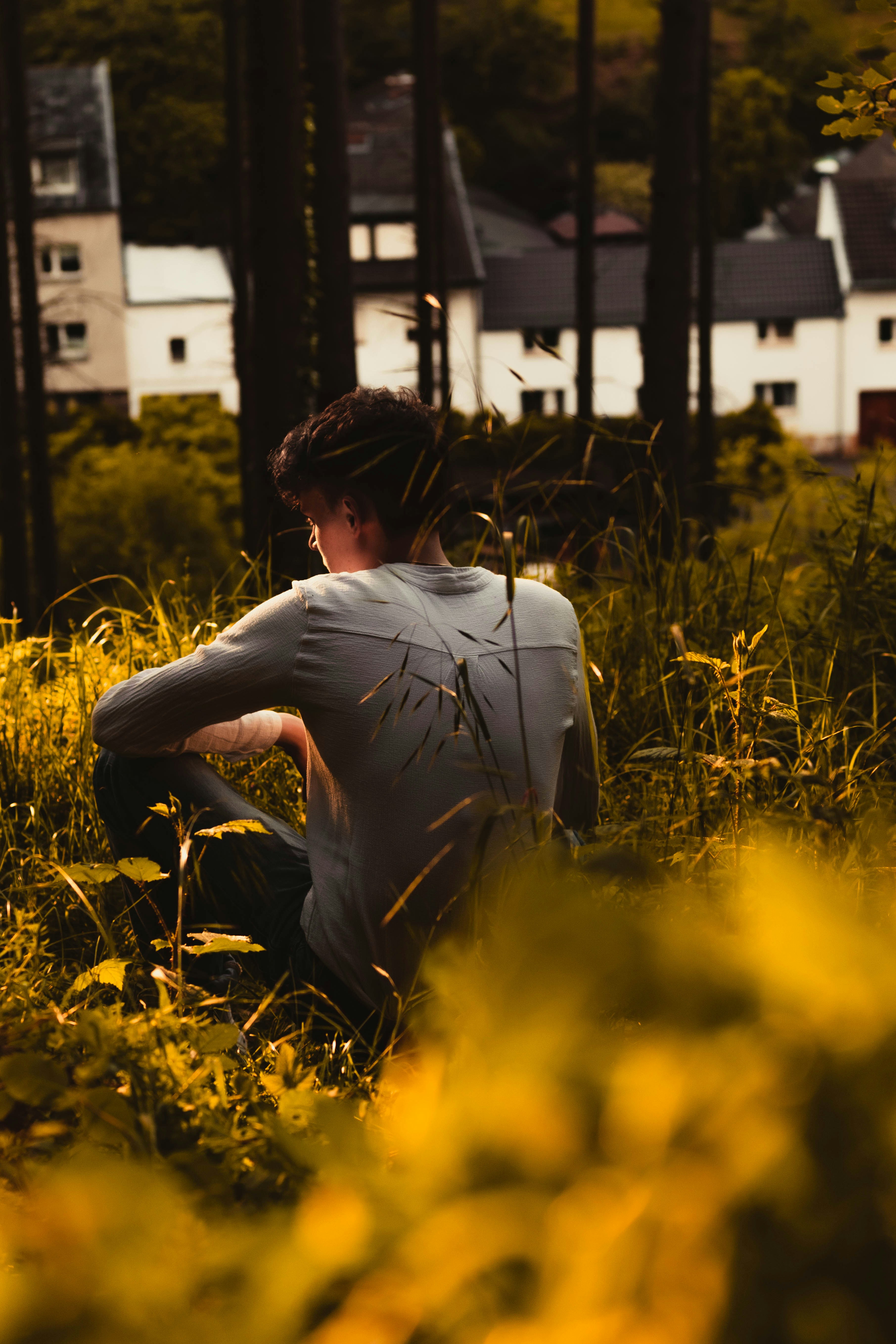 Man sitting alone on green field photo – Free Flower Image on Unsplash