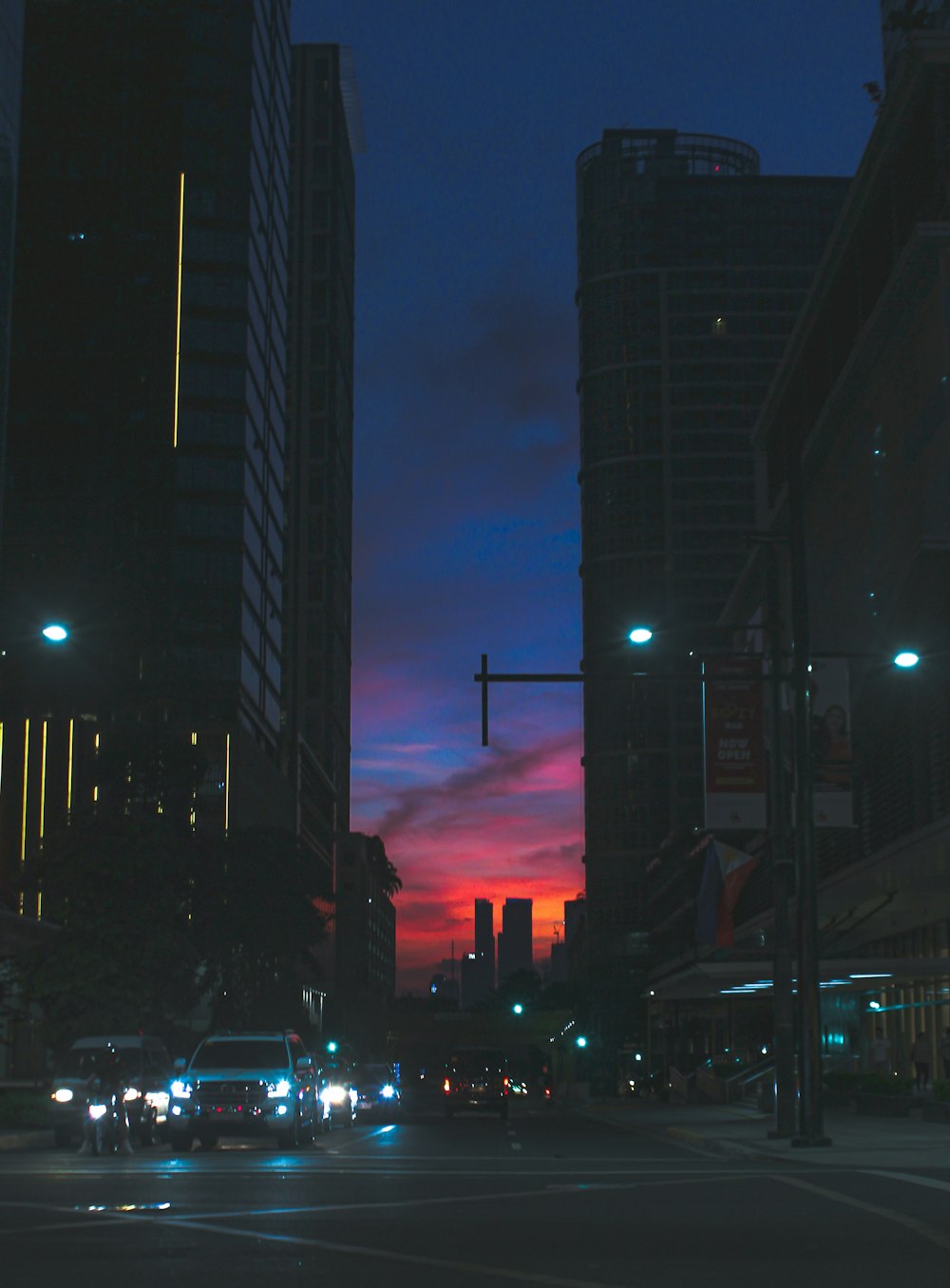 vehicle on street between high-rise buildings during golden hour