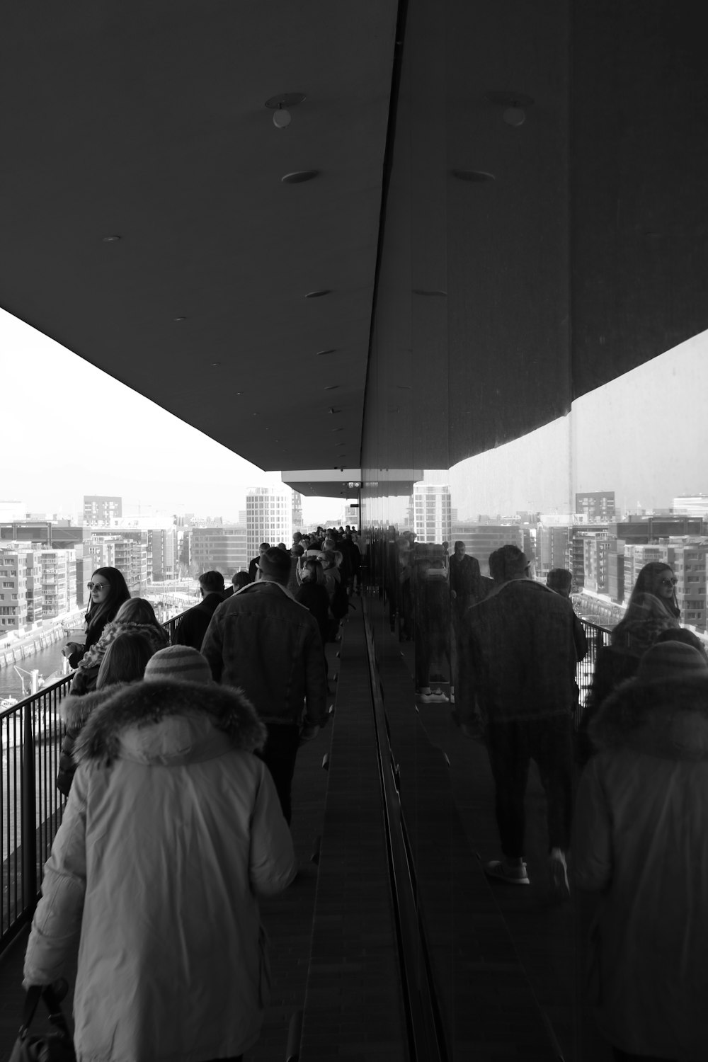 grayscale photography of people walking bridge