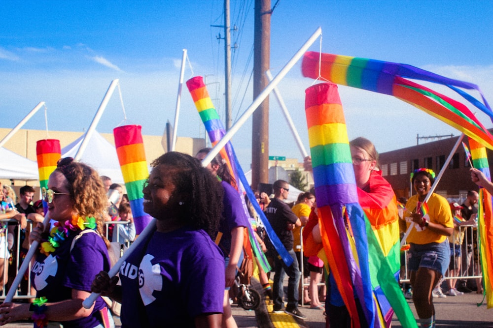 women carrying flag while walking on road