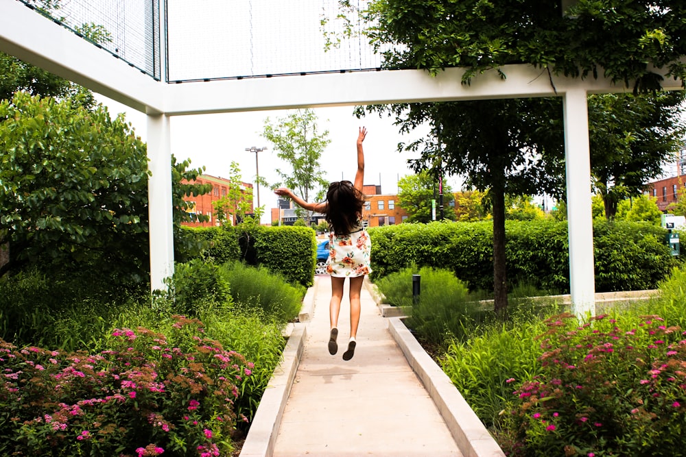 woman on mid air between flowers