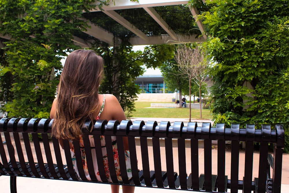 woman sitting on metal bench