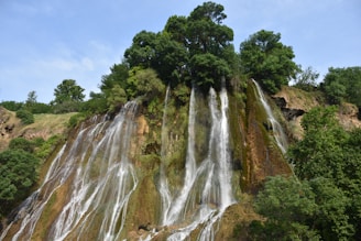 Majestic waterfall surrounded by lush greenery in a tranquil setting