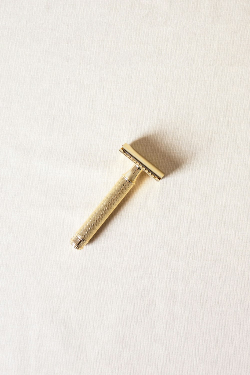 afeitadora de color dorado sobre superficie blanca